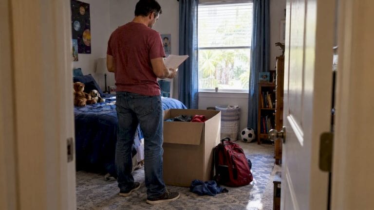 Parent reviews relocation papers in child’s room